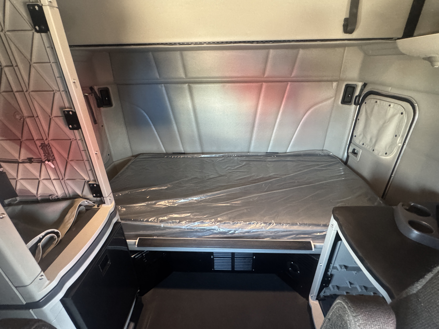 Peterbilt 579 sleeper cab interior cargo area with bed platform and storage nook visible.