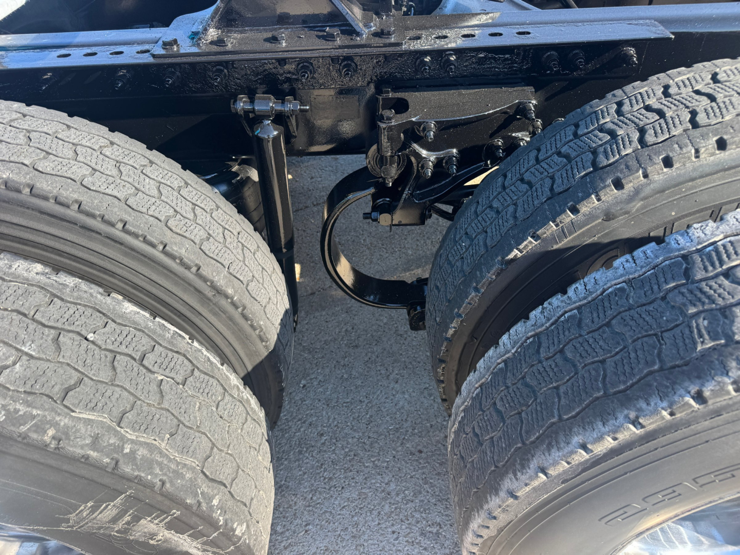 Peterbilt 579 truck chassis showing tandem rear axles and suspension components with dual tires visible.