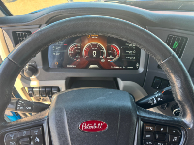 Peterbilt 579 dashboard steering wheel view showing digital instrument cluster and Peterbilt emblem on steering wheel.