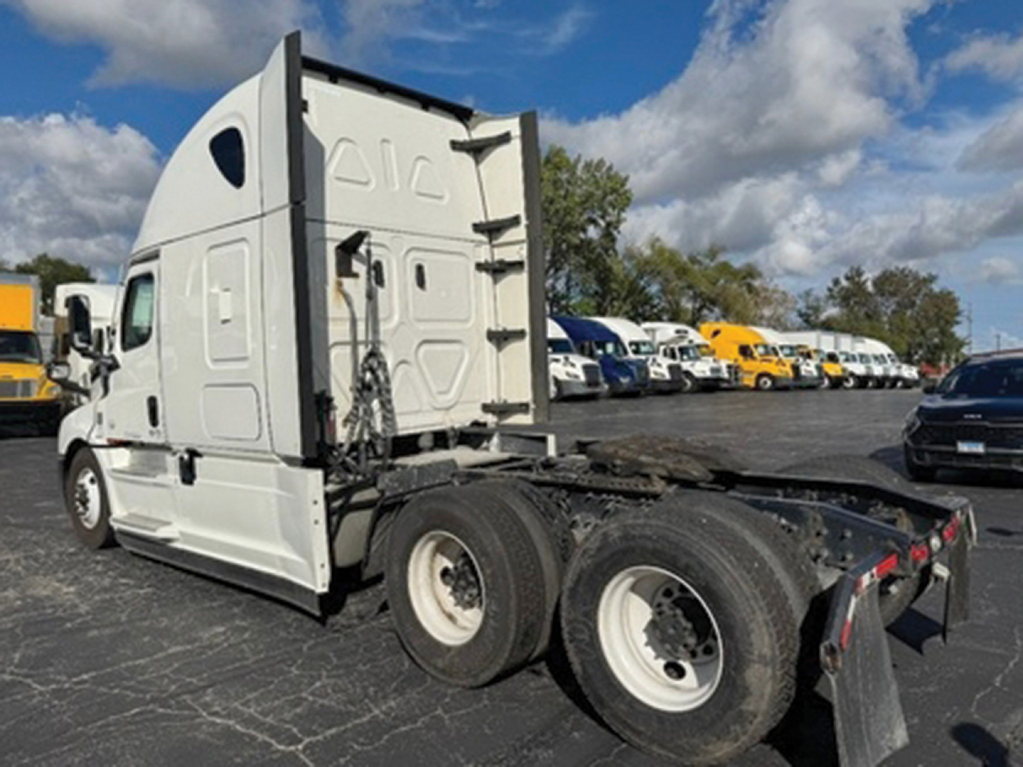 Freightliner Cascadia cab and chassis with sleeper, side view showing rear tractor wheels and fifth wheel area, no visible logos text.