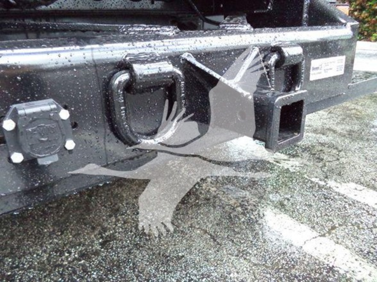 Isuzu NPR XD truck rear hitch area showing trailer hitch receiver and bumper with label sticker and connection points.