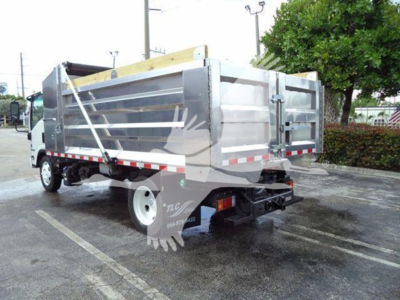 Isuzu NPR XD dump truck rear-left view showing aluminum dump bed and hydraulic components.