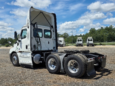 Freightliner Cascadia126 tractor cab viewed from side with raised sleeper, dual rear axles, and flatbed chassis.