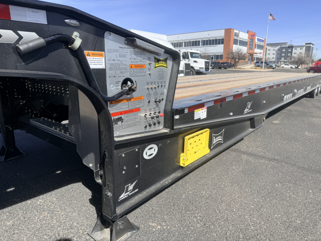 Landoll 440B-53 40 Ton traveling axle lowboy trailer side view with warning labels and yellow access panel