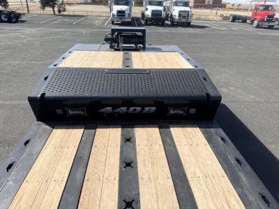 Landoll 440B-53 40-Ton traveling axle trailer deck with wooden planks and black steel frame; prominent '440B' branding on front kick plate.