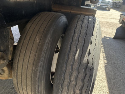 Trailer axle with dual tires on Fontaine Infinity 48' spread air combo flatbed showing treaded rear tires and wheel rims.