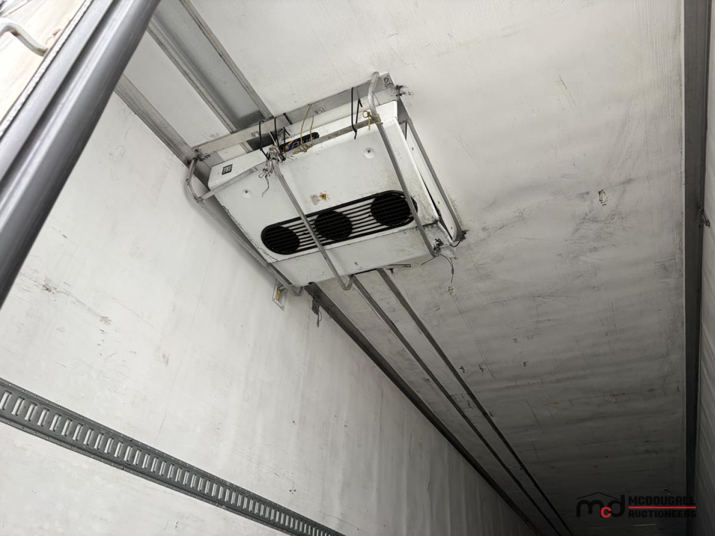 Reefer trailer ceiling unit with hanging refrigeration evaporator in box trailer interior.