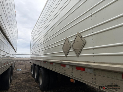 Trailer side view showing 53' refrigerated trailer with two diamond-shaped hazard placards and riveted panels.