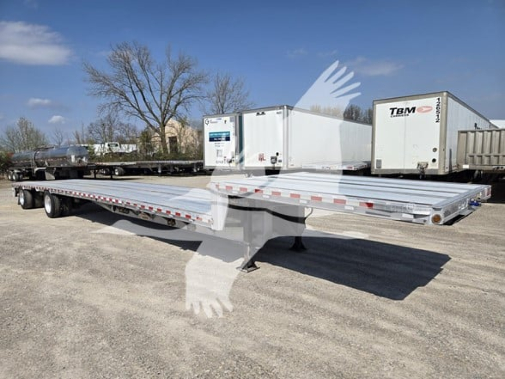 Trailer deck showing a 53-foot drop deck trailer with tandem axles and refrigeration unit in background.