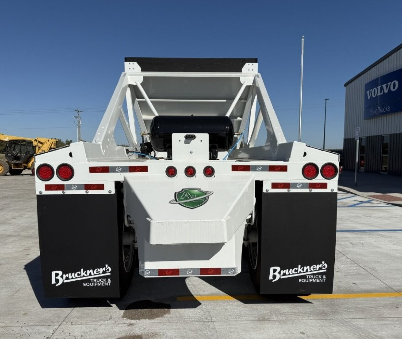 Dump trailer rear view showing white Armor Lite SBD40 skeleton frame with black mud flaps labeled 'Bruckner's Truck & Equipment' and circular taillights.