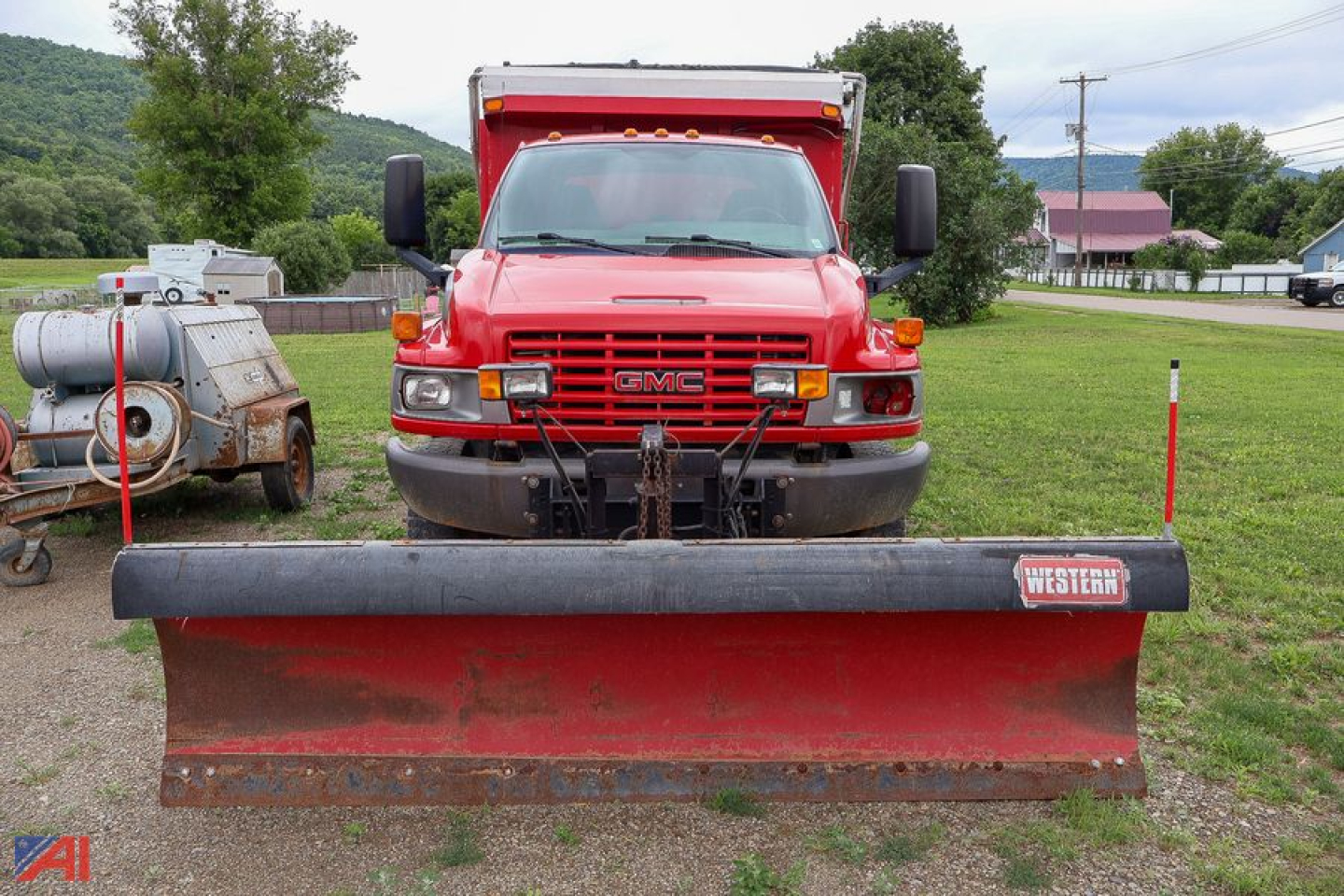 Front view of a red 2007 GMC TopKick C5500 dump truck with a wide Western snow plow attachment, in-service condition.
