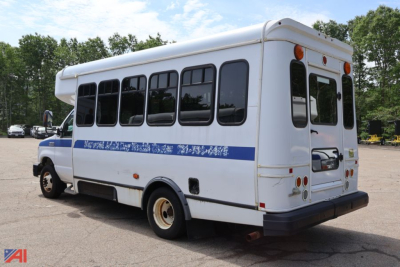 Bus rear-right view of a 2017 Ford E350 wheelchair bus with blue stripe, windows along side, orange clearance lights, and wheelchair lift area.