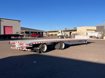  Fontaine Revolution trailer in an open lot showing a long flatbed with dual rear axles and reflective safety tape.