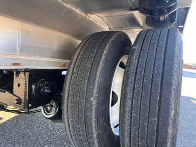 Dual rear tires and undercarriage of a Fontaine Revolution trailer showing suspension and wheel hub area.