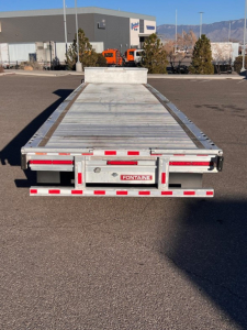 Rear view of a 2020 Fontaine Revolution drop deck trailer showing flatbed surface, rear platform, taillights, and Fontaine branding plate.