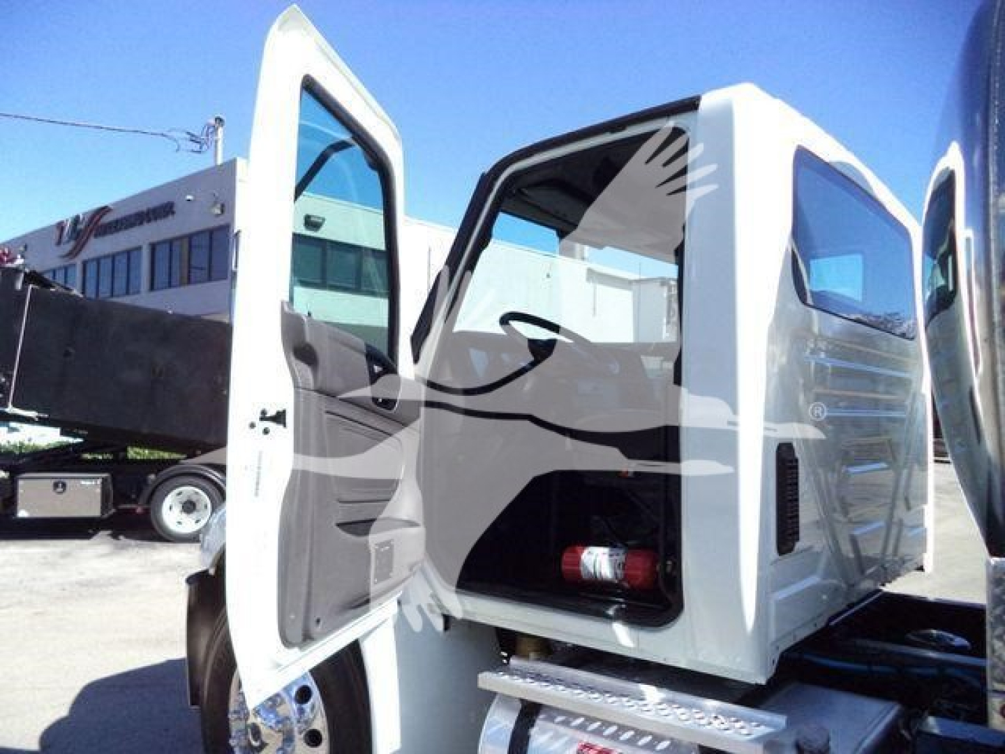 Interior of a 2021 International MV vacuum tank truck with doors open showing cab interior and vacuum area.