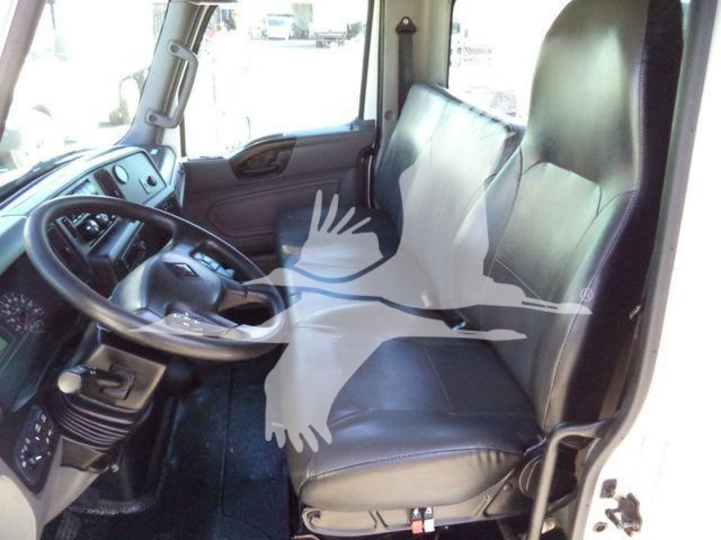 Interior of a 2021 International MV vacuum tank truck showing driver seat and passenger seat with dashboard and steering wheel.