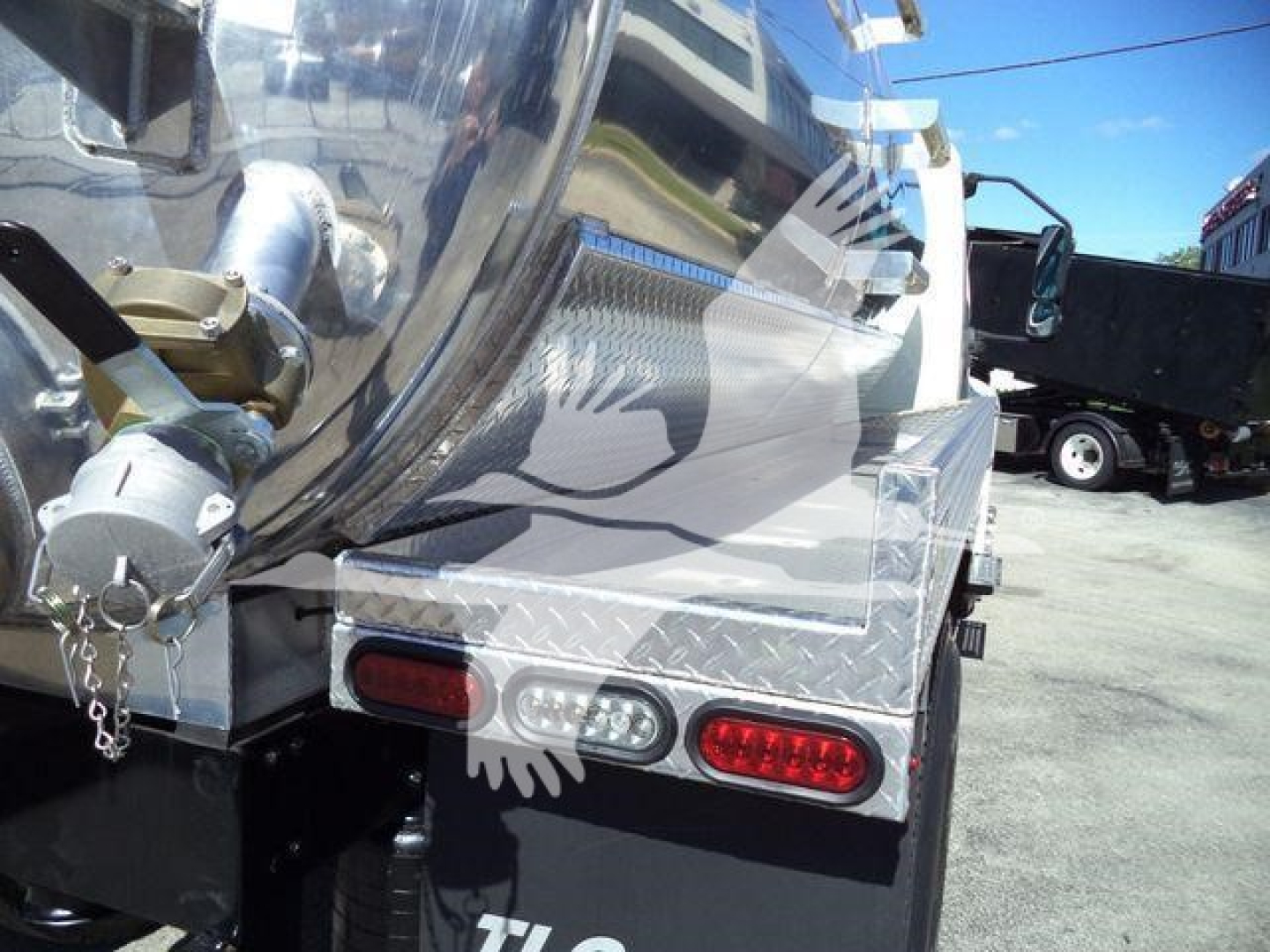Truck rear showing vacuum tank, taillights, and diamond plate aluminum end cap with hitch and hoses.