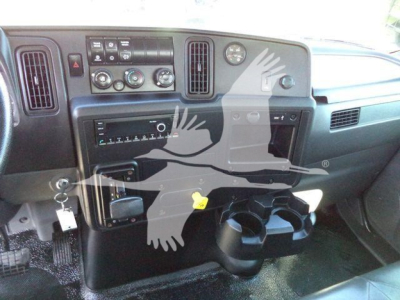 Interior of a 2021 International MV vacuum tank truck dashboard showing controls, gauges, cup holders, and key in ignition.