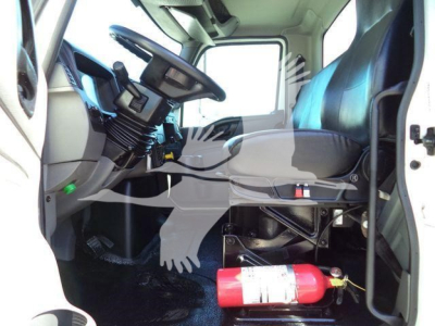 Interior of a 2021 International MV vacuum tanker truck cab showing steering wheel, seat, and a red fire extinguisher mounted beside the driver.