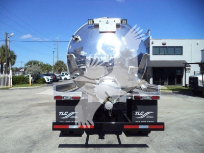 Vacuum tank truck rear view showing circular stainless tank, taillights, and bumper with TLC branding.