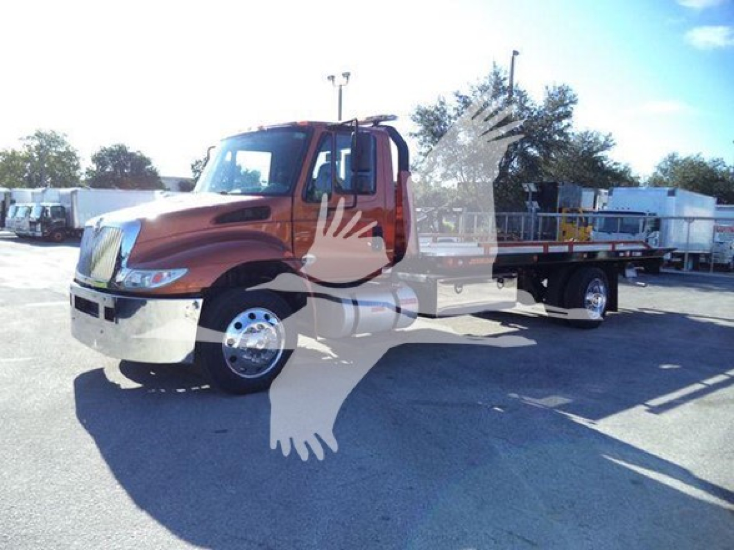 2019 International Durastar 4300 rollback truck in orange with flatbed, side view, VIN visible in listing background.