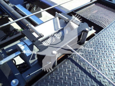 Trucks rollback equipment on platform showing hydraulic mechanism and metal diamond plate surface.