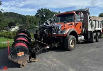 Dump truck with snow plow attachment on front, orange cab and gray dump bed, International SF547 WorkStar series truck