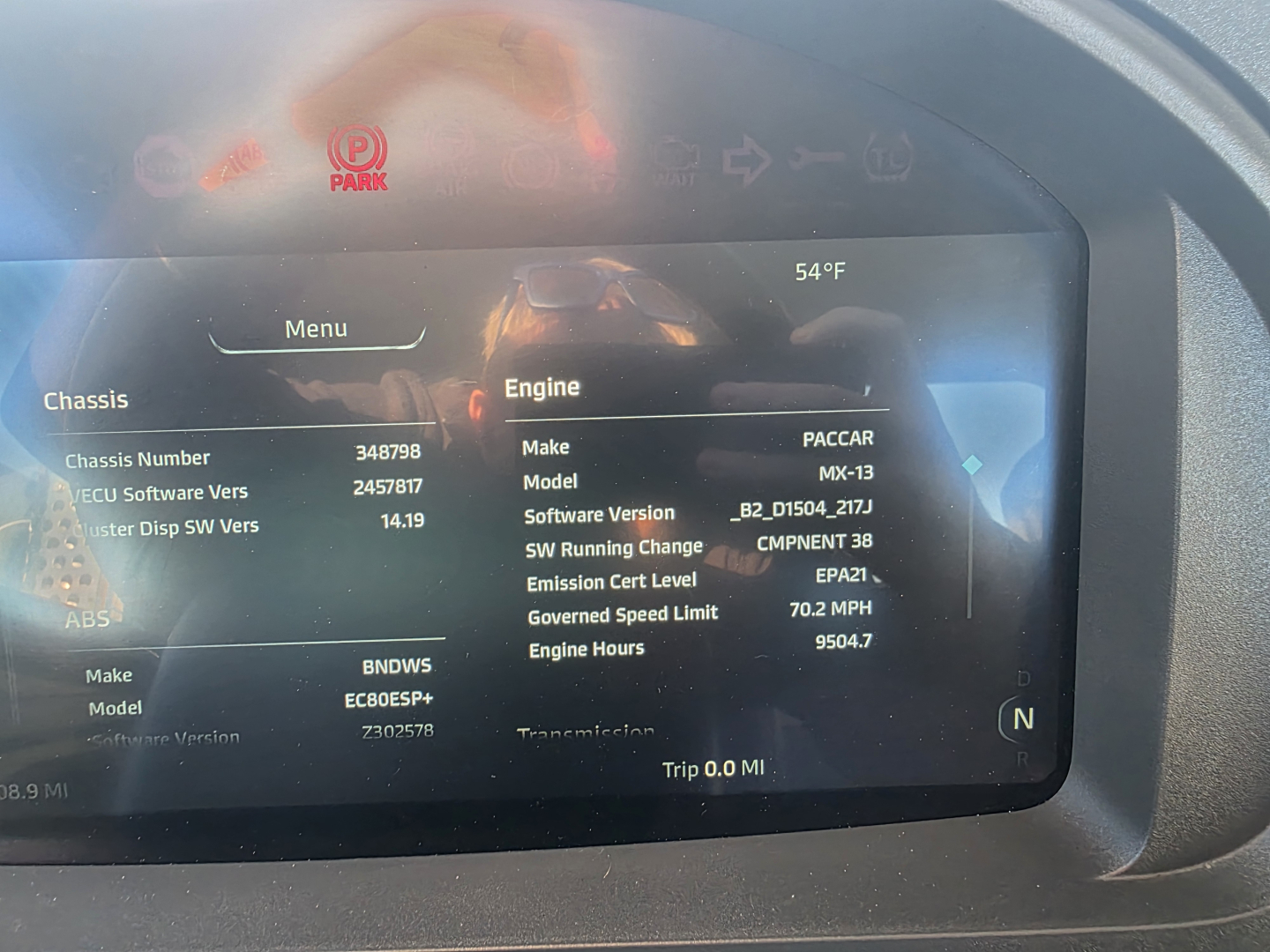Kenworth T880 dash display showing engine make/model and truck data. Engine: PACCAR MX-13, SW Running Range, Emission Cert Level EPA21, Engine Hours 9504.7, GVW speed limit 70.2 MPH, Trip 0.0 MI.