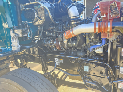 Kenworth T880 engine bay with intricate hoses and components visible.