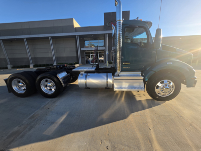 Kenworth T880 conventional daycab truck side view showing aluminum fuel tanks and chrome exhaust stacks.