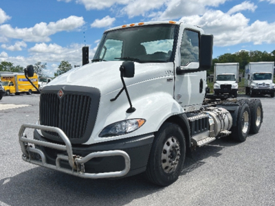 Truck cab and chassis showing International RH613, white daytime cab, with front bull guard and dual rear axles, VIN 3HSDWTZRXKN254979.