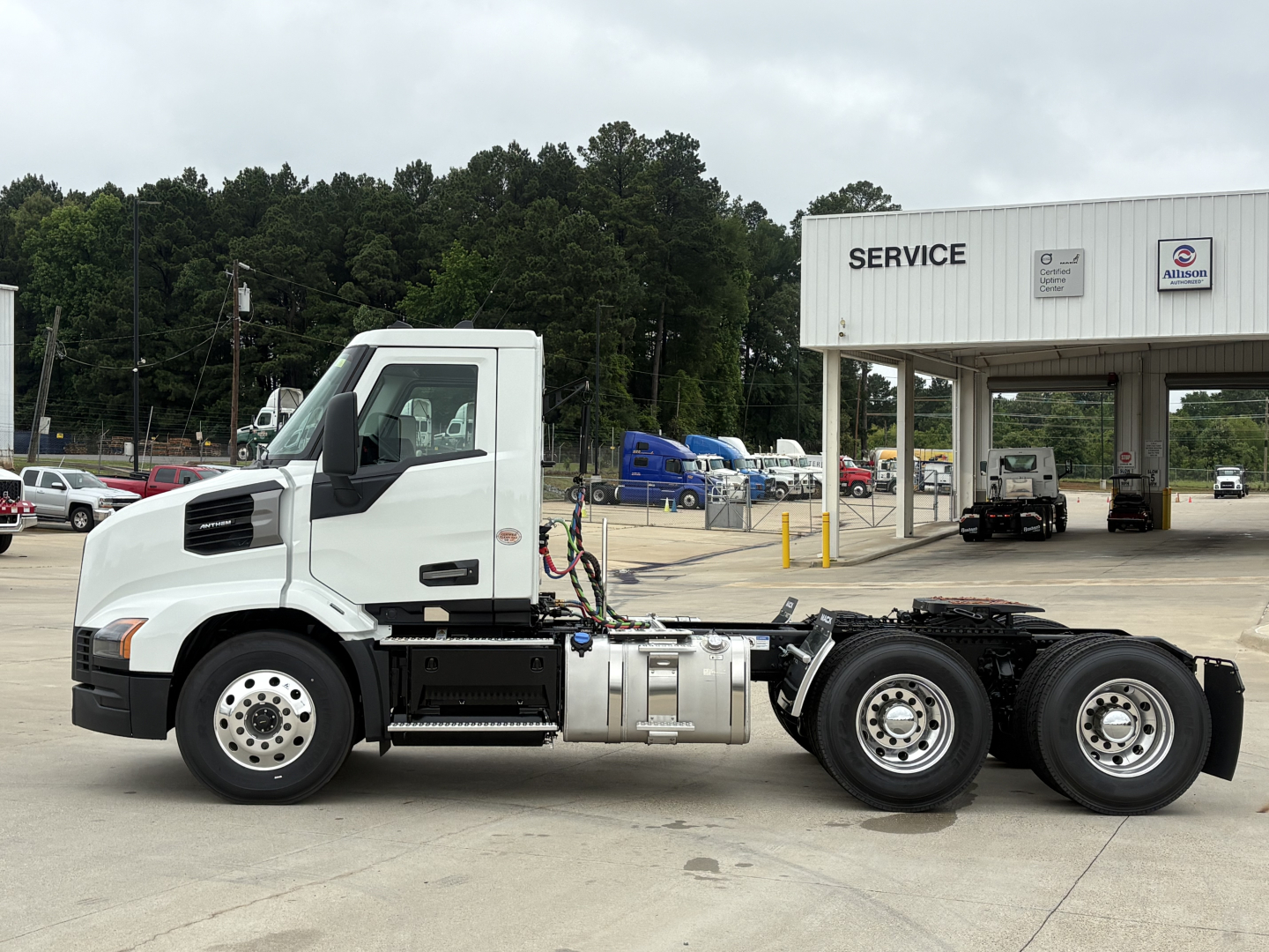 Truck chassis side view of a white Mack AN64T conventional daycab with fuel tanks and rear axles visible.
