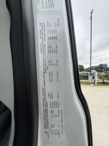 VIN/vehicle information sticker on door jamb with specs such as GVWR, payload, axle ratings, engine family, and tire information.