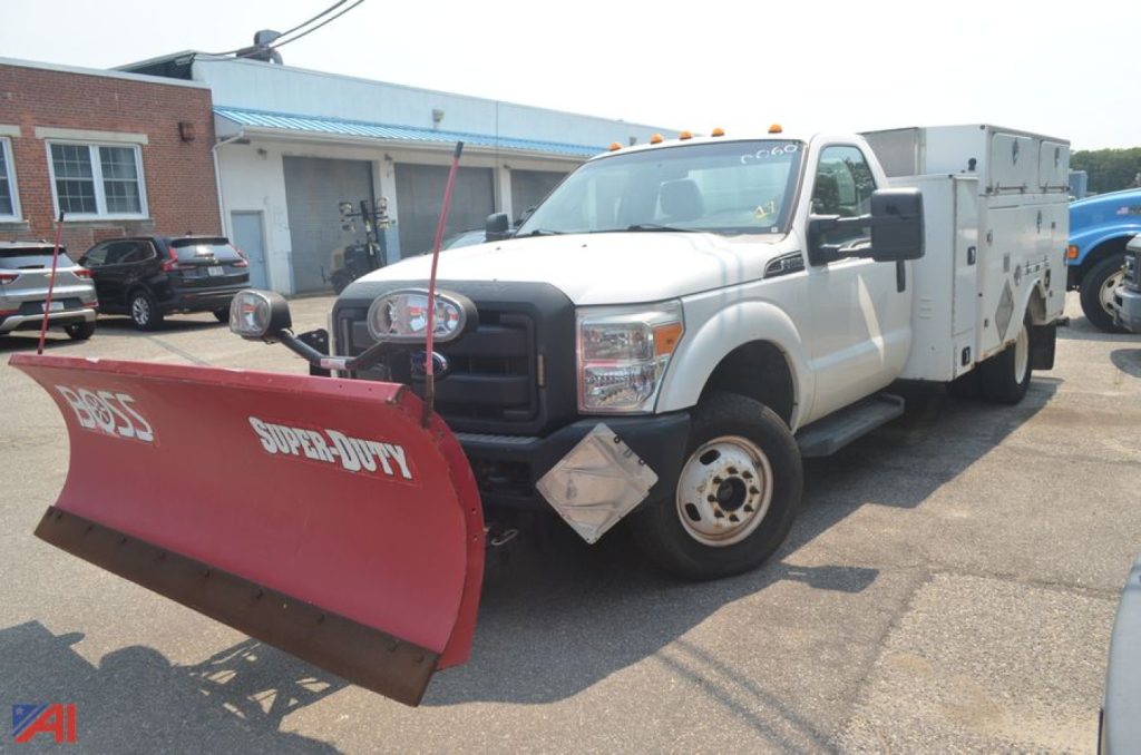 Ford F-350 Super Duty service truck with front plow and utility body, side view showing a red Power Plow blade and work compartments.