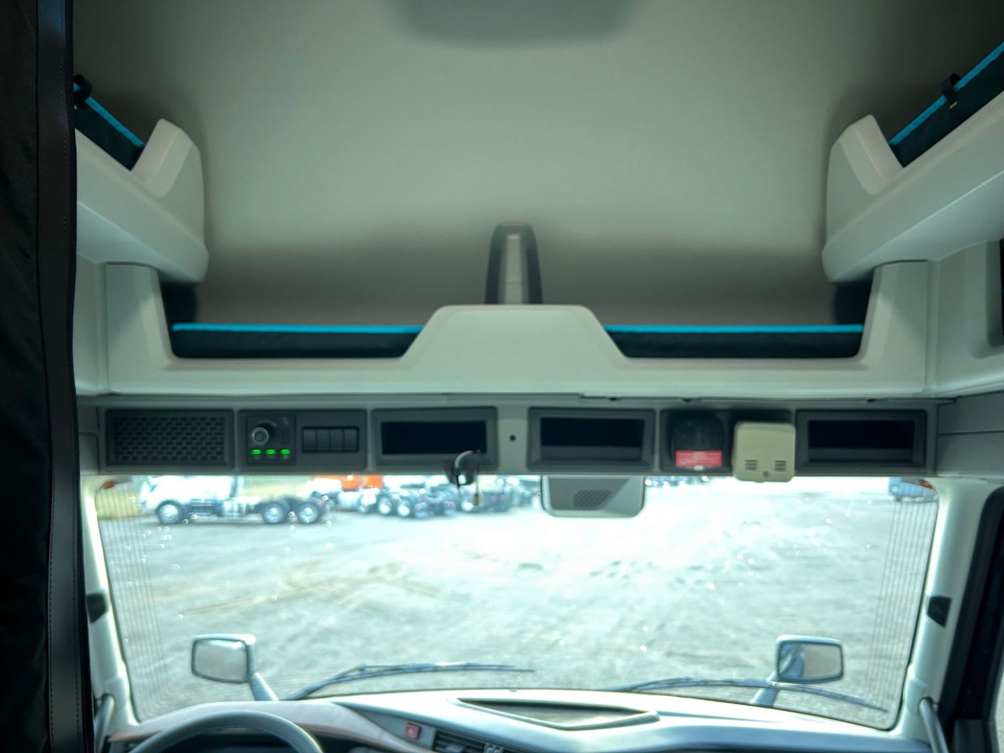 Volvo VNL cab interior ceiling view showing electronic control panel and window visors.