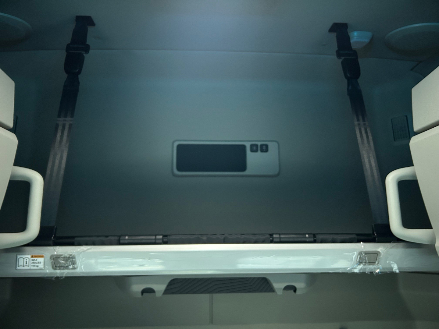 Volvo VNL64T660 cab interior storage area with vertical straps and a small central panel.