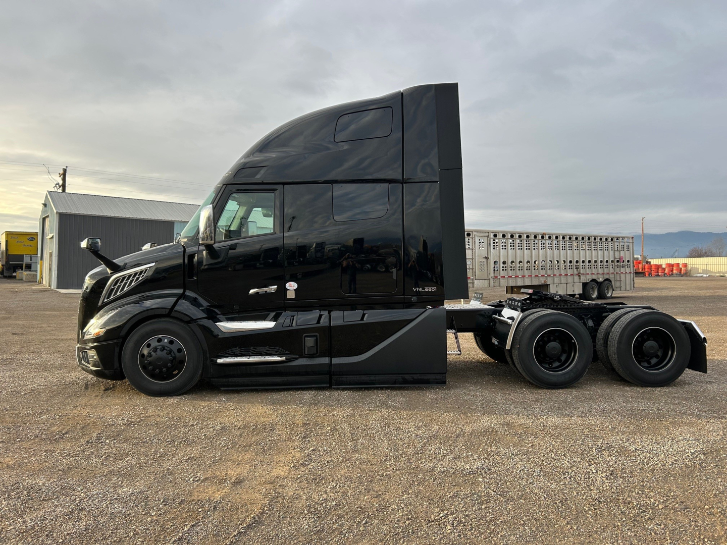 Volvo VNL64T660 tractor side view showing aerodynamic black cab and dual rear axles.