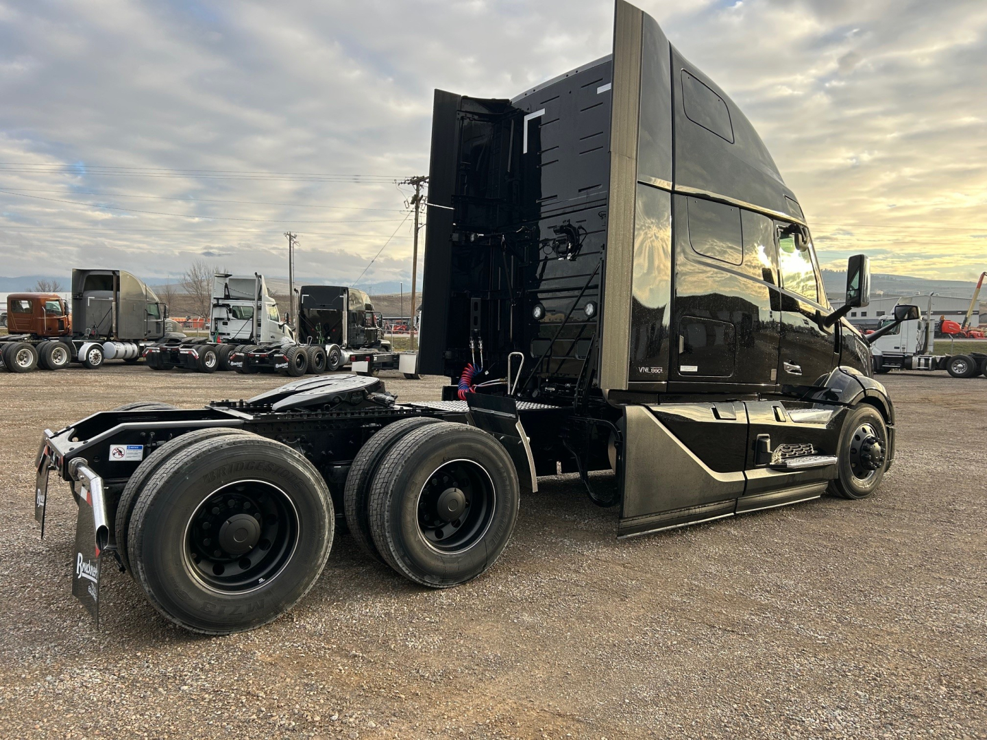 Volvo VNL64T660 truck in profile, 6x4 tractor with black sleeper cab and dual rear axles, exterior view of the chassis and cab.