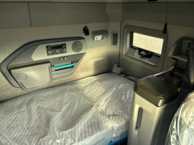 Volvo VNL interior sleeper cab with control panel, storage compartments, window, and seating area visible.