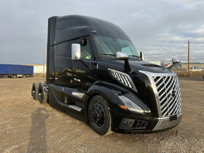 Volvo VNL64T660 sleeper tractor with black exterior, front grille, chrome mirrors, and large aerodynamic hood showing chrome accents.