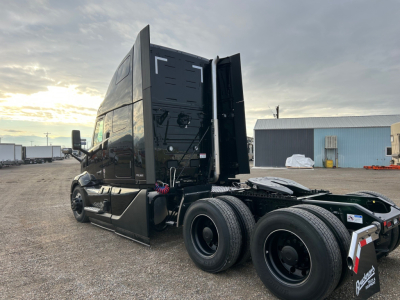 Volvo VNL64T660 tractor cab side and rear showing 6x4 wheel configuration and high-roof sleeper.