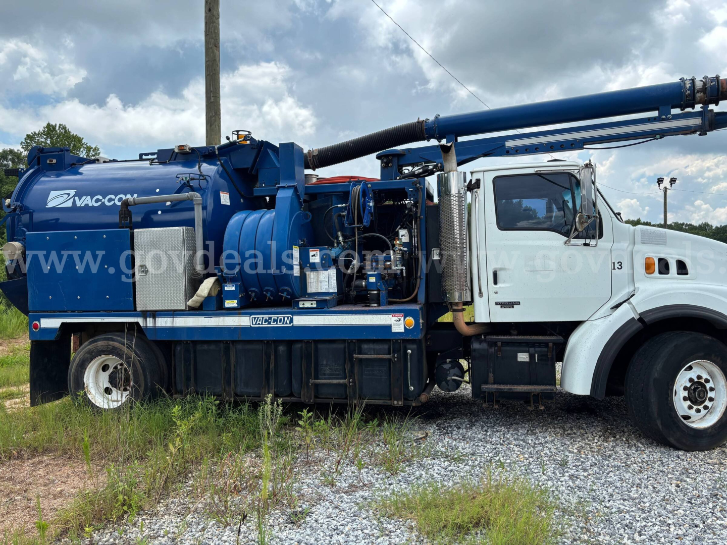 Vac Con vacuum truck mounted on Sterling L7500 chassis showing blue vacuum tank and hose reel. Side view with cab and equipment, stock number overlay not legible.