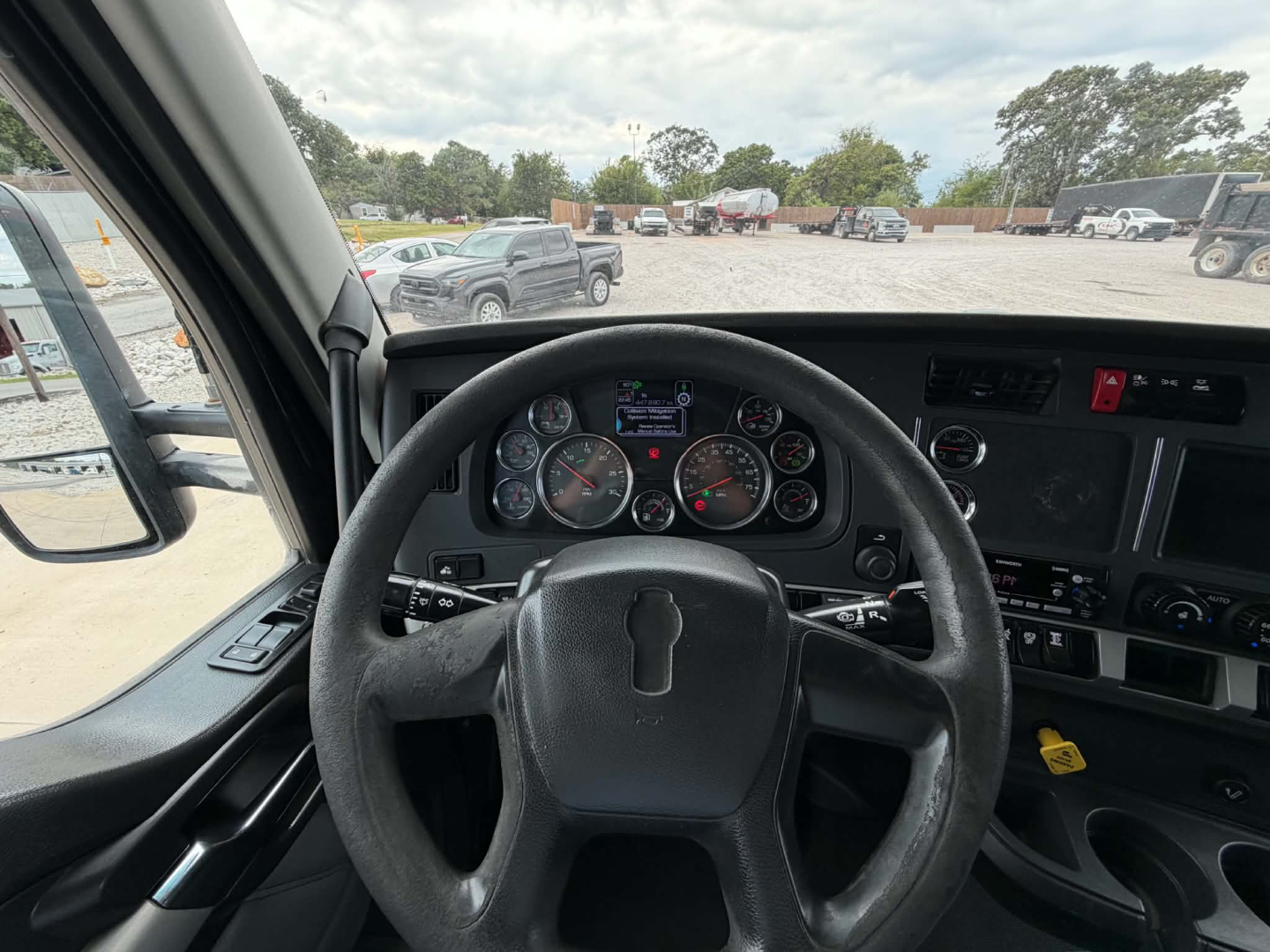 Kenworth T680 cabin dashboard and steering wheel with instrument cluster and controls visible.