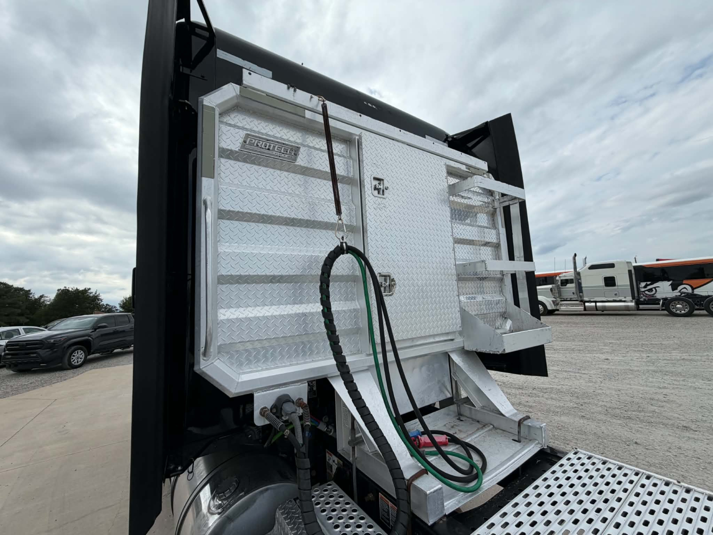 Kenworth T680 service body platform showing rear view with utility boxes and hoses attached.