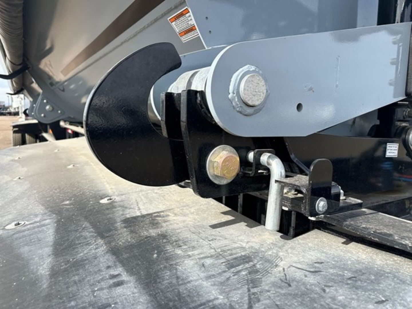 Trailer hitch and suspension of a 2026 Jet Air Ride Side Dump showing a large black auger-like propeller and gray mounting brackets with bolts.