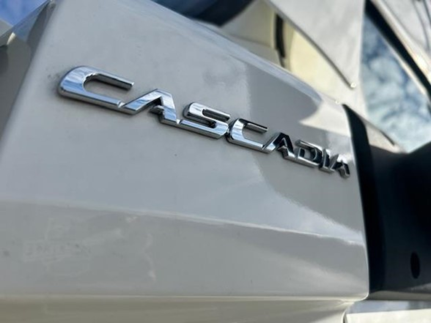 Freightliner Cascadia 126 badge on truck tailgate showing 'CASCADIA' chrome emblem.