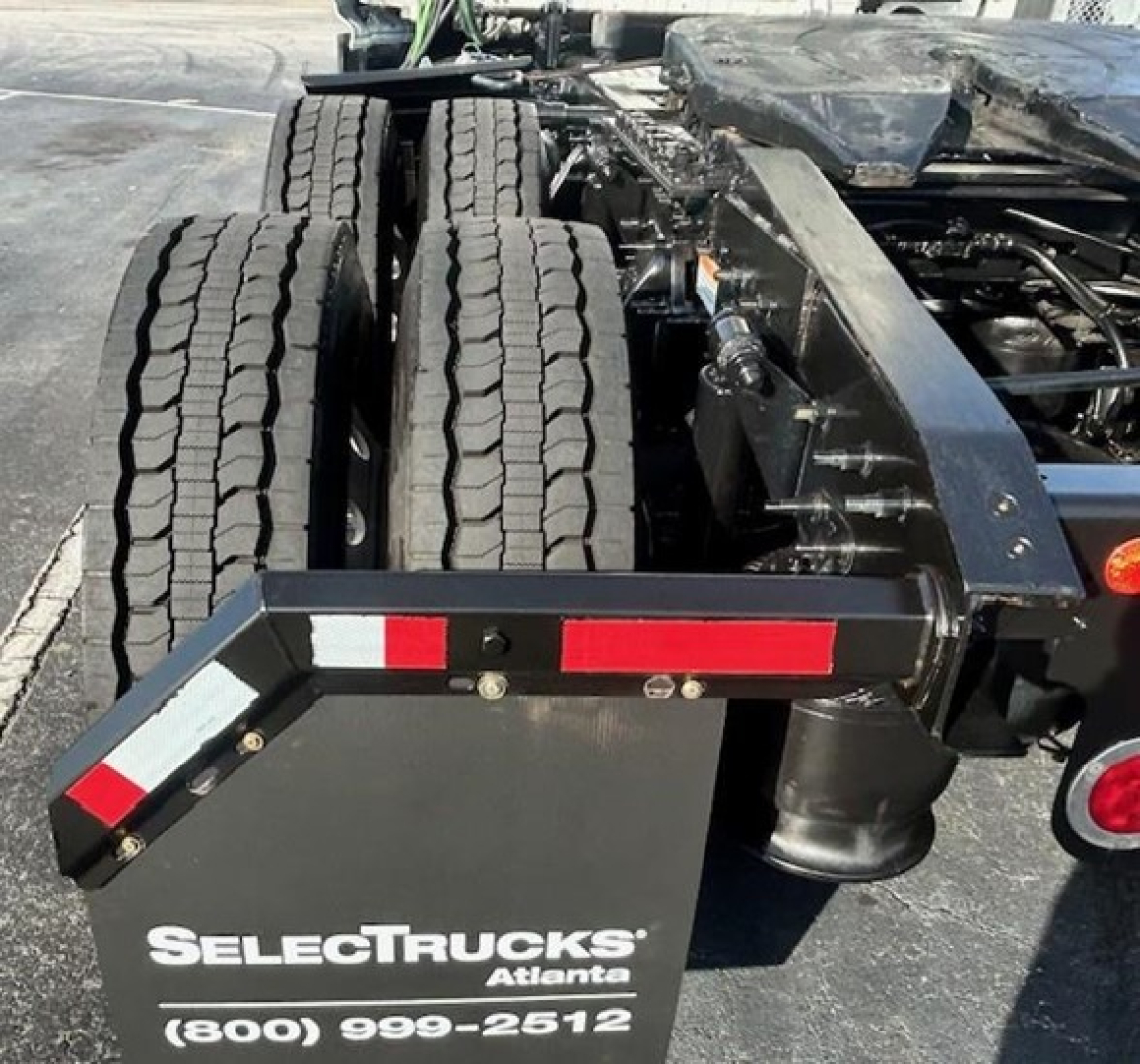 Freightliner Cascadia 126 wheel area showing dual rear axles and rear fender with SelectTrucks Atlanta branding and phone number.