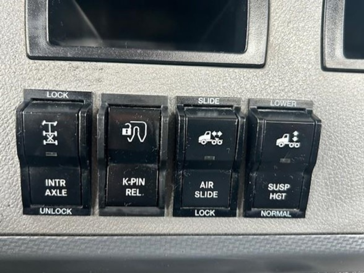 Dashboard switches with lock, slide, lower, intra axle, K-PIN release, air slide, suspension height labels.