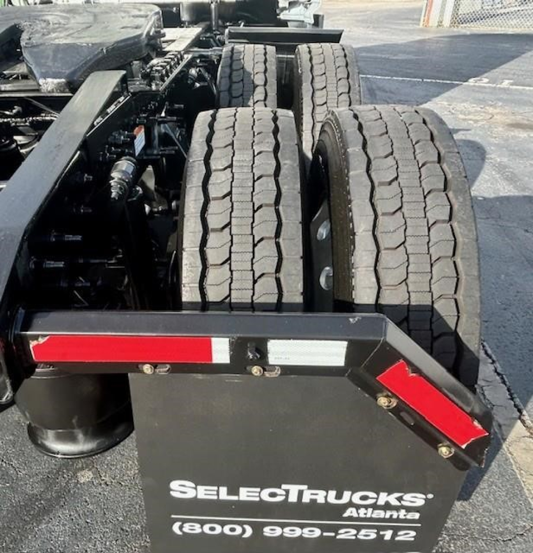 Trucks chassis shown with dual rear axles and undercarriage components; SelectTrucks Atlanta plate and bumper visible.